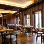 Warm restaurant dining room with wood surfaces and pendant lights