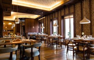 Warm restaurant dining room with wood surfaces and pendant lights