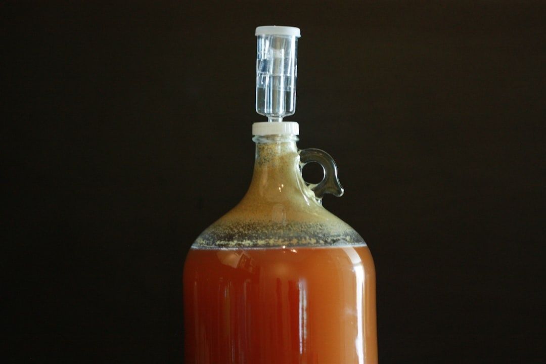Glass demijohn of amber fermenting liquid with an airlock