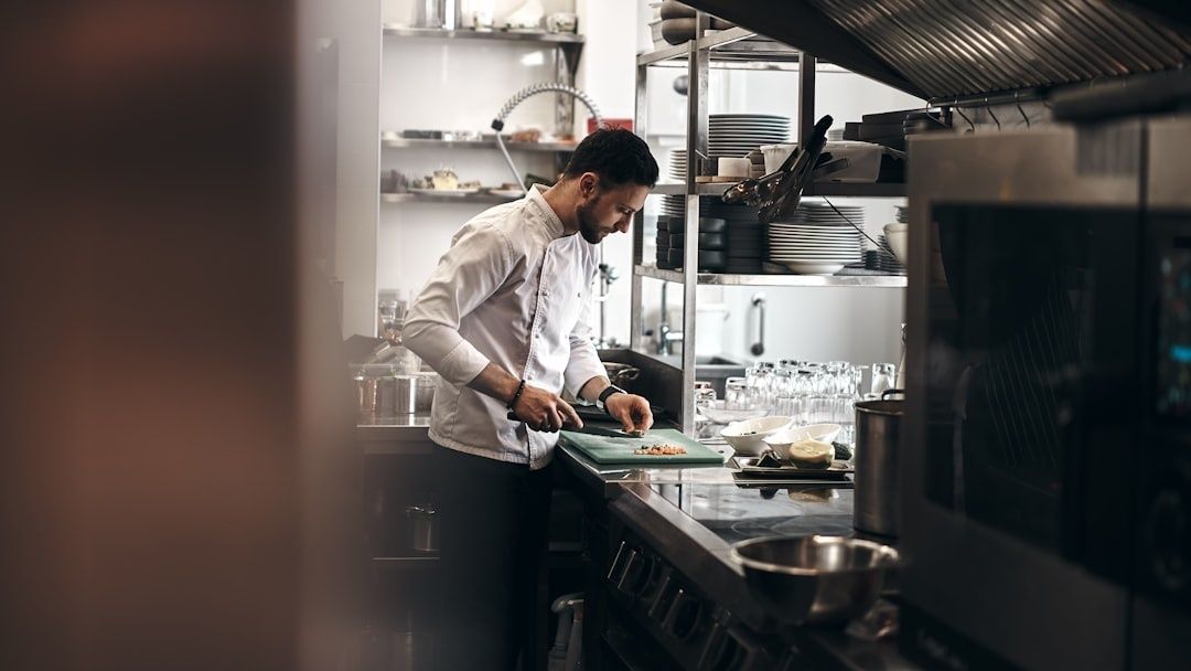 Chef chopping ingredients at a compact galley kitchen workstation